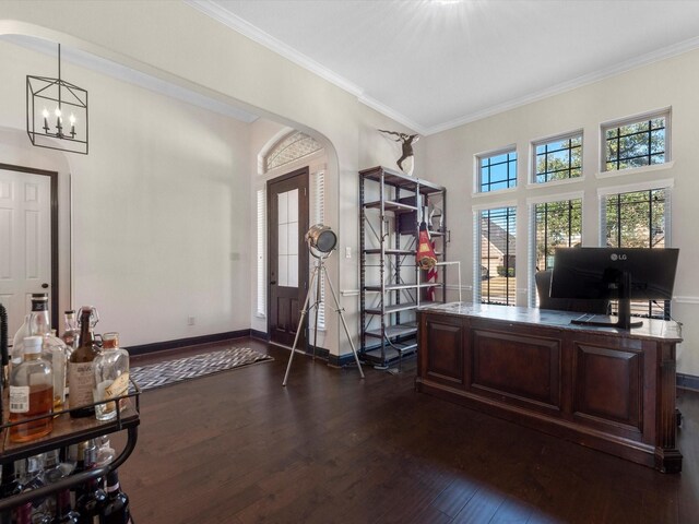office area featuring dark wood-style flooring, ornamental molding, arched walkways, a chandelier, and baseboards