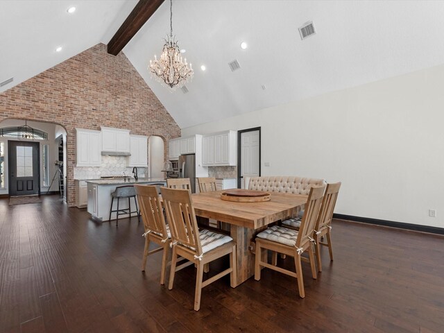 dining area featuring a chandelier, dark wood finished floors, high vaulted ceiling, arched walkways, and beam ceiling
