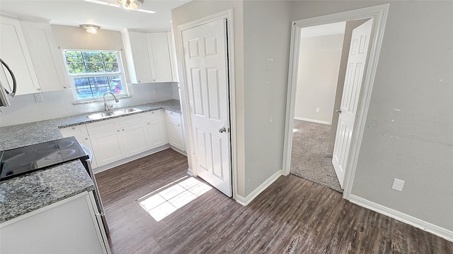 1314 Burbank St, Baytown, TX 77520 - kitchen featuring a sink, white cabinetry, dark wood-type flooring, backsplash, and light stone counters