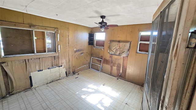 1314 Burbank St, Baytown, TX 77520 - empty room with tile patterned floors, wooden walls, and a ceiling fan