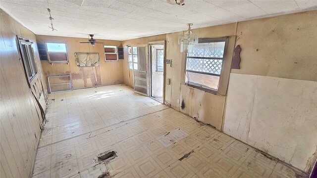 1314 Burbank St, Baytown, TX 77520 - spare room with light floors, wood walls, and ceiling fan