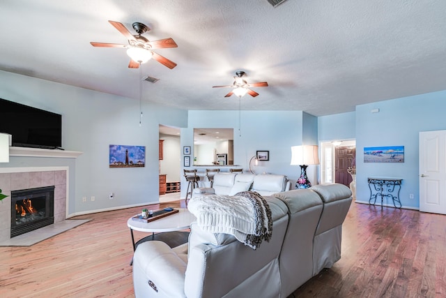 410 Scarlet Sage Dr, League City, TX 77573 - living room featuring a ceiling fan, wood finished floors, a fireplace, and a textured ceiling