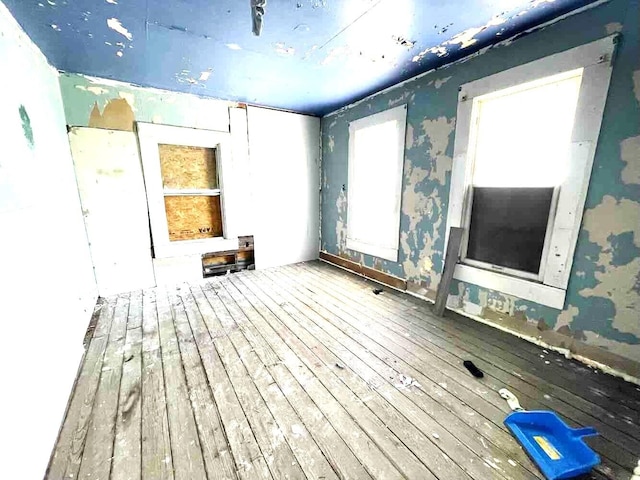 spare room featuring hardwood / wood-style floors and wallpapered walls