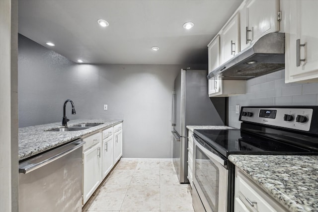 kitchen with stainless steel appliances, a sink, under cabinet range hood, backsplash, and white cabinetry