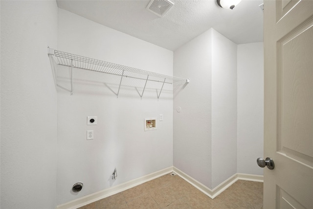 clothes washing area with electric dryer hookup, gas dryer hookup, washer hookup, baseboards, and light tile patterned floors