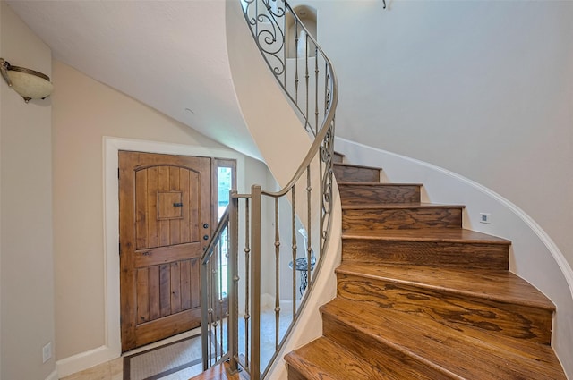 stairs with baseboards and lofted ceiling
