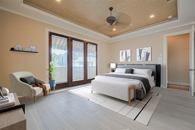 bedroom with a raised ceiling, ornamental molding, and access to outside