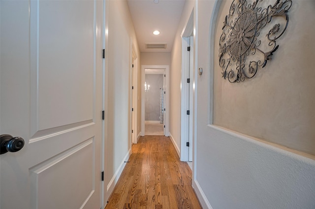 hall with light wood-style flooring, baseboards, visible vents, and recessed lighting