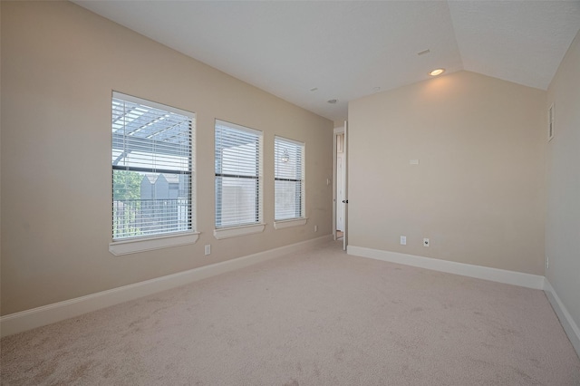 unfurnished room with light carpet, baseboards, and lofted ceiling