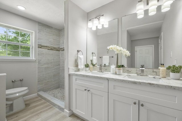 1819 Redwood Ct, Sugar Land, TX 77498 - full bathroom with double vanity, toilet, wood finished floors, tiled shower, and a sink