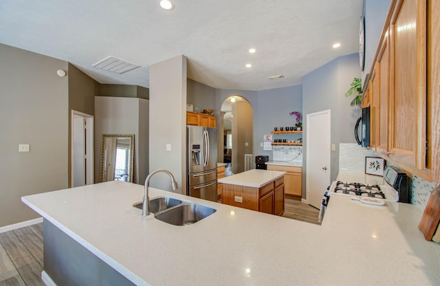 14022 Cypress Falls Dr, Cypress, TX 77429 - kitchen featuring stainless steel fridge, white range with gas cooktop, a sink, arched walkways, and open shelves