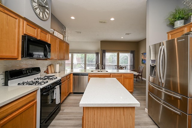 14022 Cypress Falls Dr, Cypress, TX 77429 - kitchen with stainless steel appliances, a peninsula, a center island, a sink, and decorative backsplash
