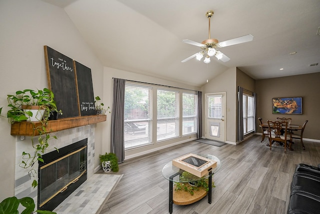 14022 Cypress Falls Dr, Cypress, TX 77429 - living room with vaulted ceiling, baseboards, ceiling fan, a tile fireplace, and light wood-type flooring