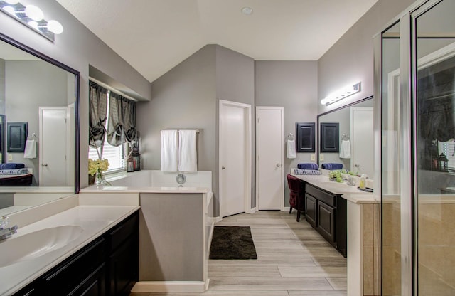 14022 Cypress Falls Dr, Cypress, TX 77429 - full bathroom with vaulted ceiling, two vanities, wood finished floors, and a stall shower