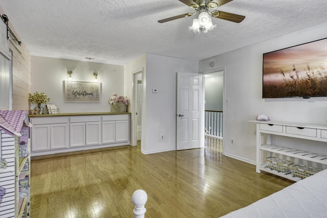 1985 Eastridge Ln, Madisonville, TX 77864 - living room with a textured ceiling, baseboards, a ceiling fan, and light wood-type flooring