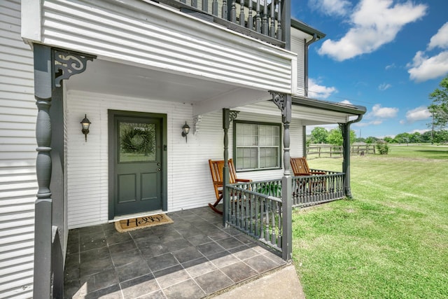 1985 Eastridge Ln, Madisonville, TX 77864 - view of exterior entry with a yard, a porch, and a balcony