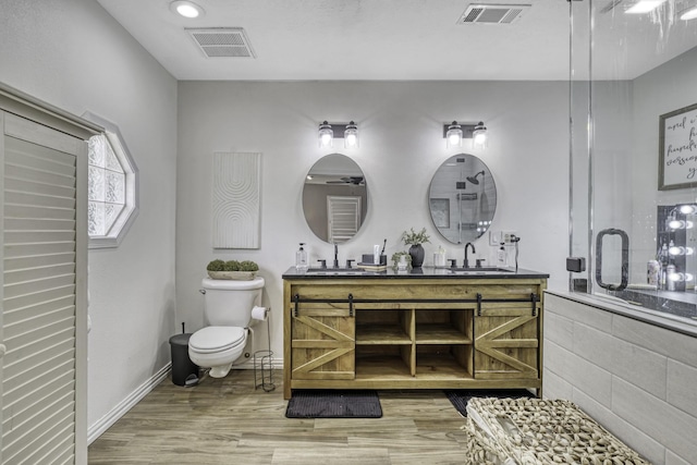 1985 Eastridge Ln, Madisonville, TX 77864 - full bath with toilet, visible vents, a sink, and wood finished floors