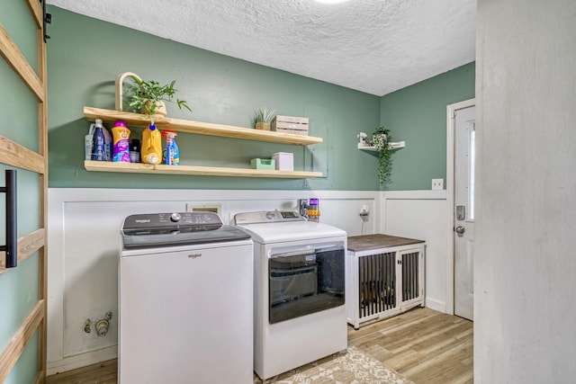 1985 Eastridge Ln, Madisonville, TX 77864 - washroom featuring washing machine and clothes dryer, laundry area, a textured ceiling, and wood finished floors