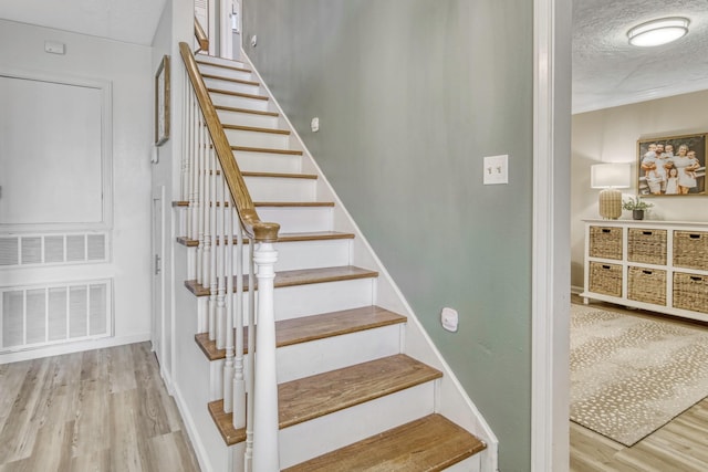 1985 Eastridge Ln, Madisonville, TX 77864 - staircase with a textured ceiling, visible vents, and wood finished floors