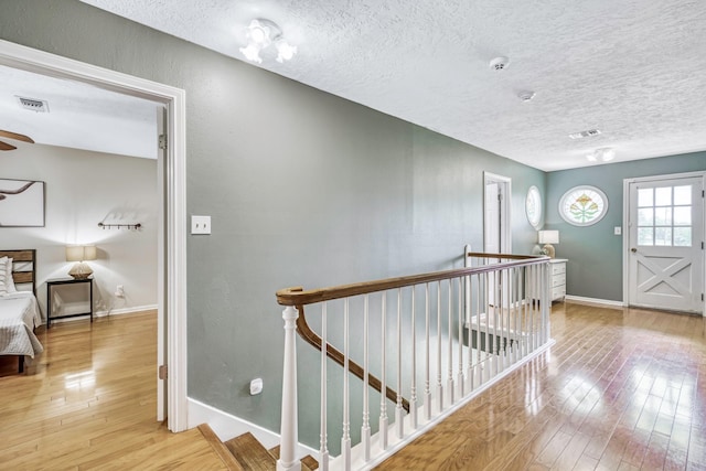 1985 Eastridge Ln, Madisonville, TX 77864 - corridor featuring hardwood / wood-style flooring, a textured ceiling, an upstairs landing, and visible vents