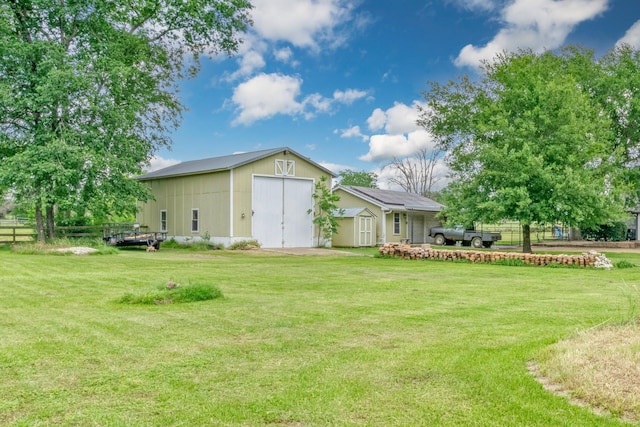1985 Eastridge Ln, Madisonville, TX 77864 - rear view of property featuring a yard, an outdoor structure, a storage shed, and fence