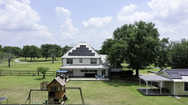 1985 Eastridge Ln, Madisonville, TX 77864 - rear view of property with a playground, a patio, solar panels, and a fenced backyard