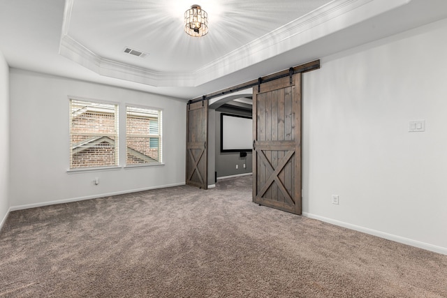 16202 Coyote Run Ln, Cypress, TX 77433 - unfurnished bedroom with a barn door, crown molding, carpet, and a tray ceiling
