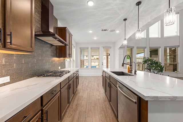 16202 Coyote Run Ln, Cypress, TX 77433 - kitchen featuring appliances with stainless steel finishes, wall chimney range hood, plenty of natural light, light wood-style floors, and recessed lighting