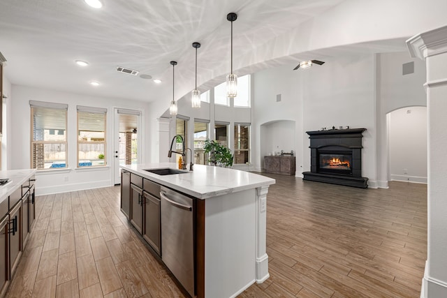 16202 Coyote Run Ln, Cypress, TX 77433 - kitchen with dishwasher, light wood-type flooring, a glass covered fireplace, open floor plan, and pendant lighting