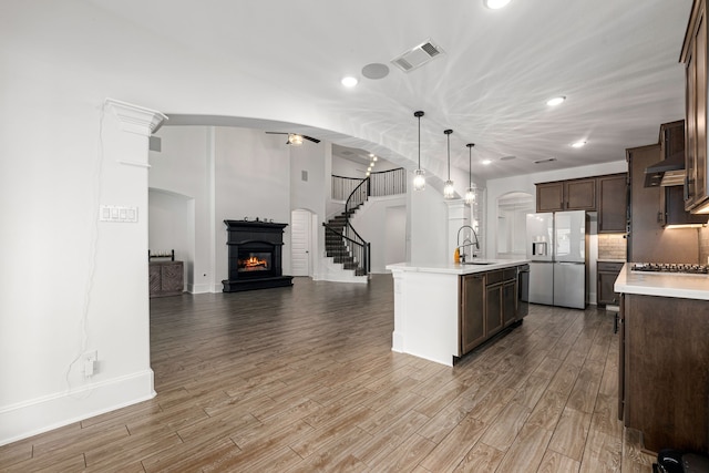 16202 Coyote Run Ln, Cypress, TX 77433 - kitchen with stainless steel appliances, open floor plan, light countertops, a glass covered fireplace, and recessed lighting