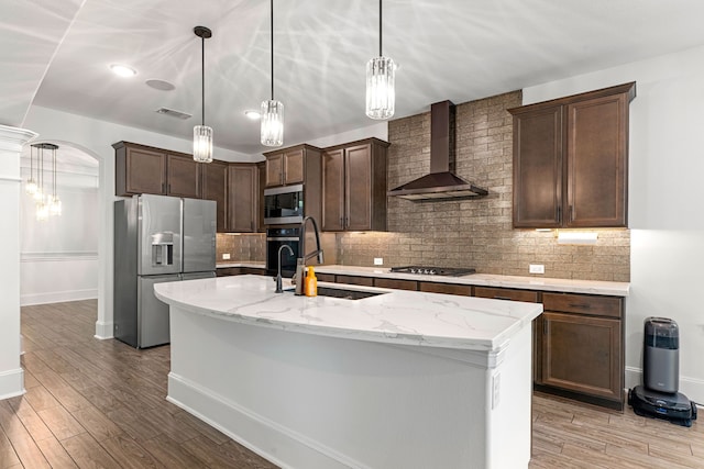 16202 Coyote Run Ln, Cypress, TX 77433 - kitchen featuring wall chimney exhaust hood, stainless steel appliances, dark brown cabinets, and light stone countertops
