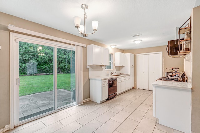 kitchen featuring white cabinets, dishwasher, light countertops, and a chandelier