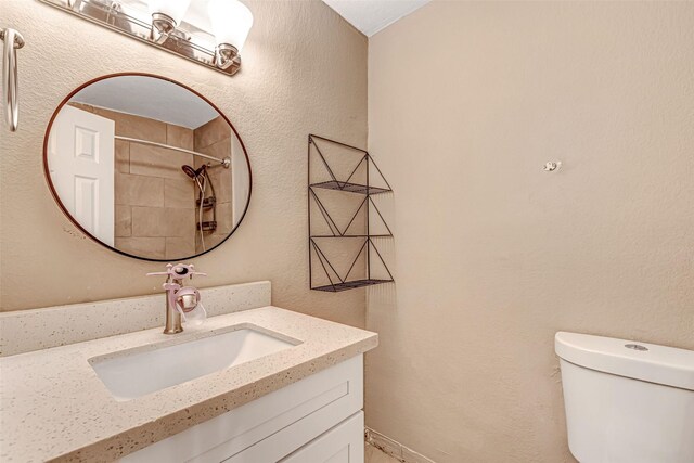 bathroom featuring curtained shower, vanity, and toilet