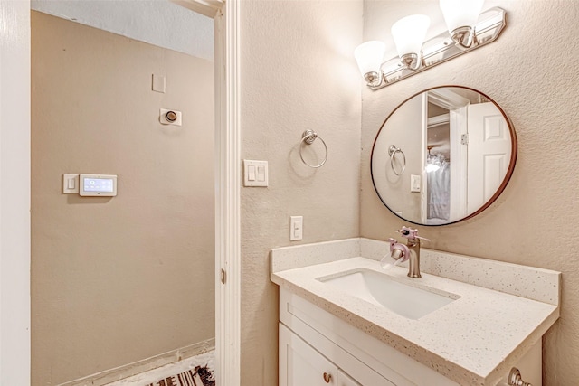 bathroom featuring vanity and a textured wall