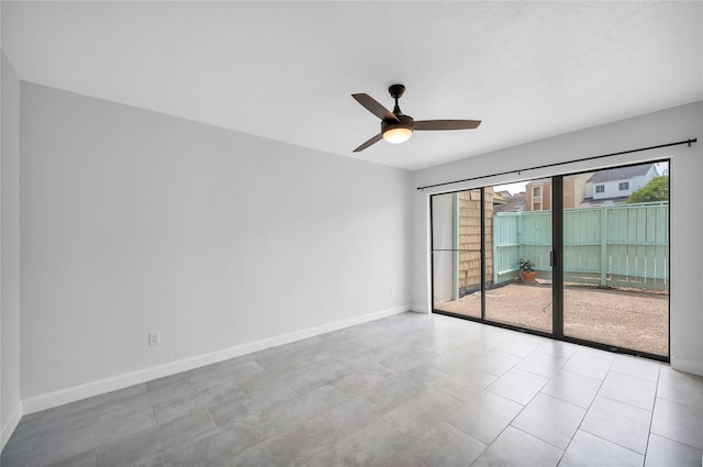 empty room featuring ceiling fan, a wealth of natural light, and baseboards