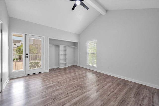 unfurnished bedroom with a closet, wood finished floors, beamed ceiling, a ceiling fan, and baseboards