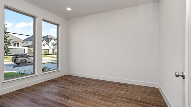 unfurnished room featuring baseboards, dark wood finished floors, and recessed lighting