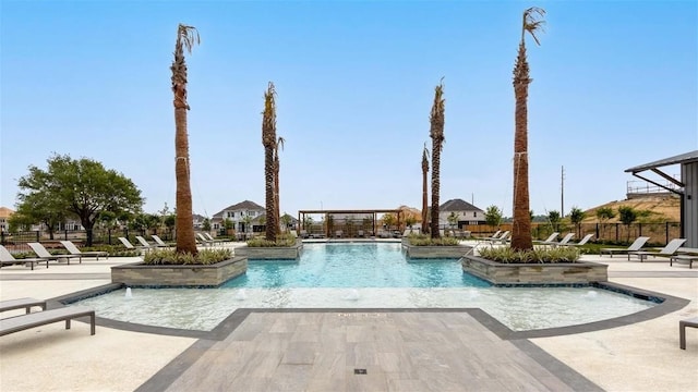 community pool with a patio area and fence