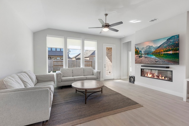 444 Texoma Plains Dr, Conroe, TX 77304 - living area featuring baseboards, a glass covered fireplace, ceiling fan, visible vents, and wood finished floors