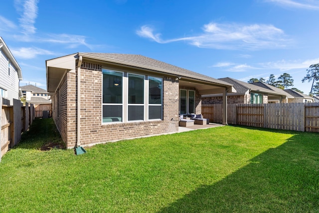 444 Texoma Plains Dr, Conroe, TX 77304 - back of house featuring a patio area, brick siding, a yard, a fenced backyard, and an outdoor hangout area