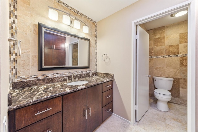 bathroom featuring vanity, toilet, tile walls, tile patterned flooring, and baseboards