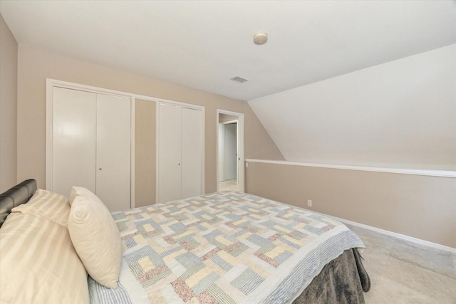 bedroom with lofted ceiling, baseboards, and two closets