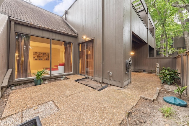 rear view of property with roof with shingles and fence