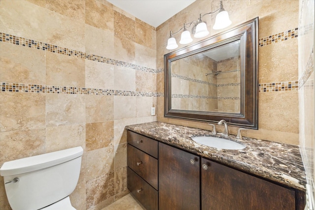 bathroom with tile walls, vanity, and toilet