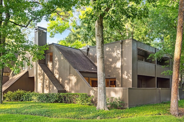 179 Litchfield Ln, Houston, TX 77024 - view of side of property with a chimney and roof with shingles