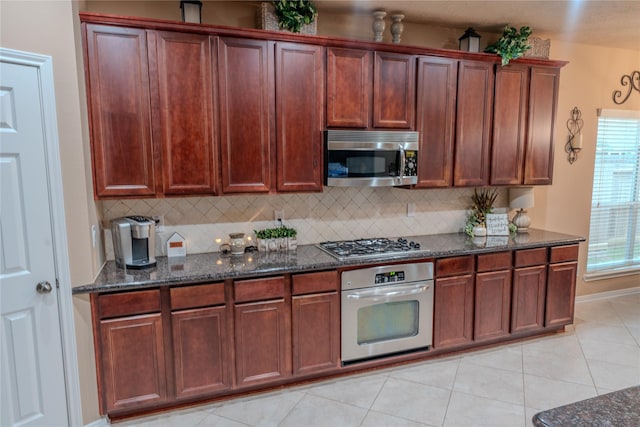 3519 Maverly Crest Ct, Katy, TX 77494 - kitchen featuring appliances with stainless steel finishes, dark stone countertops, backsplash, and light tile patterned floors