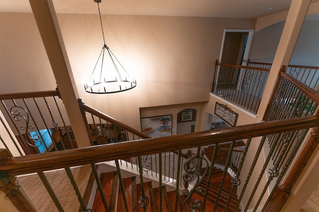 stairway with a chandelier and wood finished floors