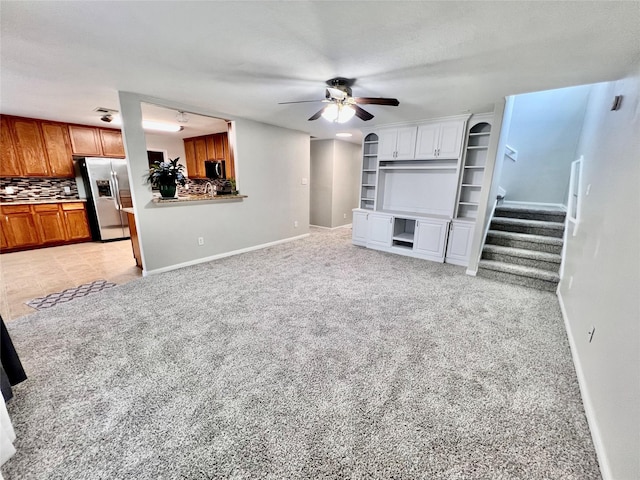 21618 Falvel Lake Dr, Spring, TX 77388 - unfurnished living room with stairway, baseboards, ceiling fan, and light carpet