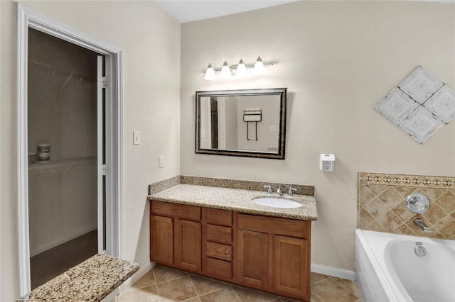 21618 Falvel Lake Dr, Spring, TX 77388 - bathroom featuring tile patterned floors, vanity, a garden tub, and a walk in closet