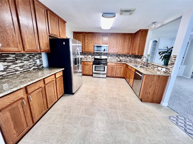 21618 Falvel Lake Dr, Spring, TX 77388 - kitchen with brown cabinetry, stainless steel appliances, decorative backsplash, and a sink